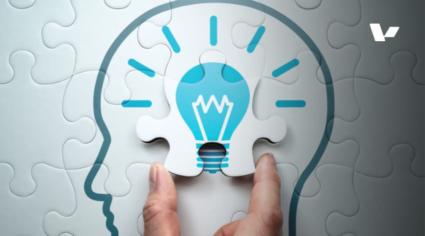 A hand placing a puzzle piece shaped like a light bulb into the puzzle, symbolizing the moment of insight or problem-solving. The image represents innovation and creativity in problem-solving.