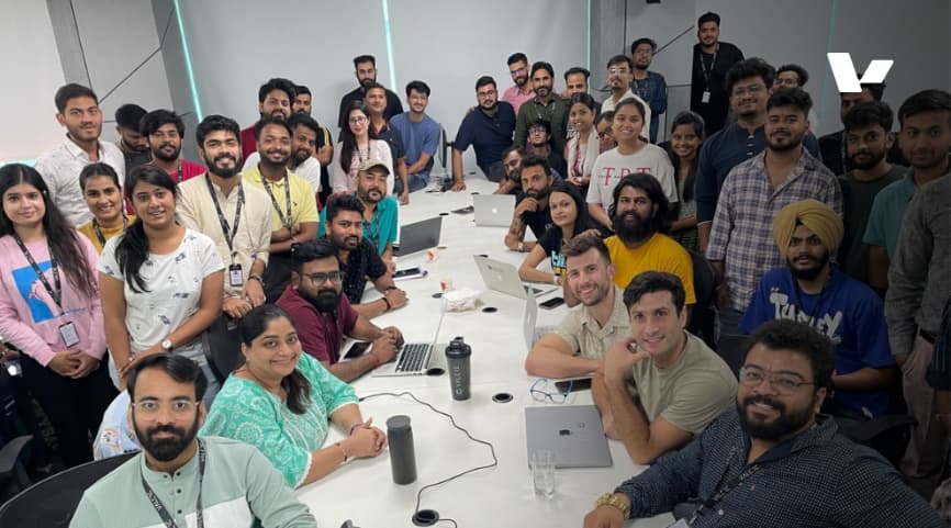 Valere team photo in a collaborative workspace, showcasing a diverse group of professionals working together in a modern office environment.