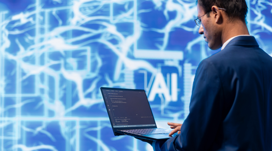 A man in a suit works on a laptop displaying code, with a glowing 'AI' graphic and abstract neural network visuals in the background.