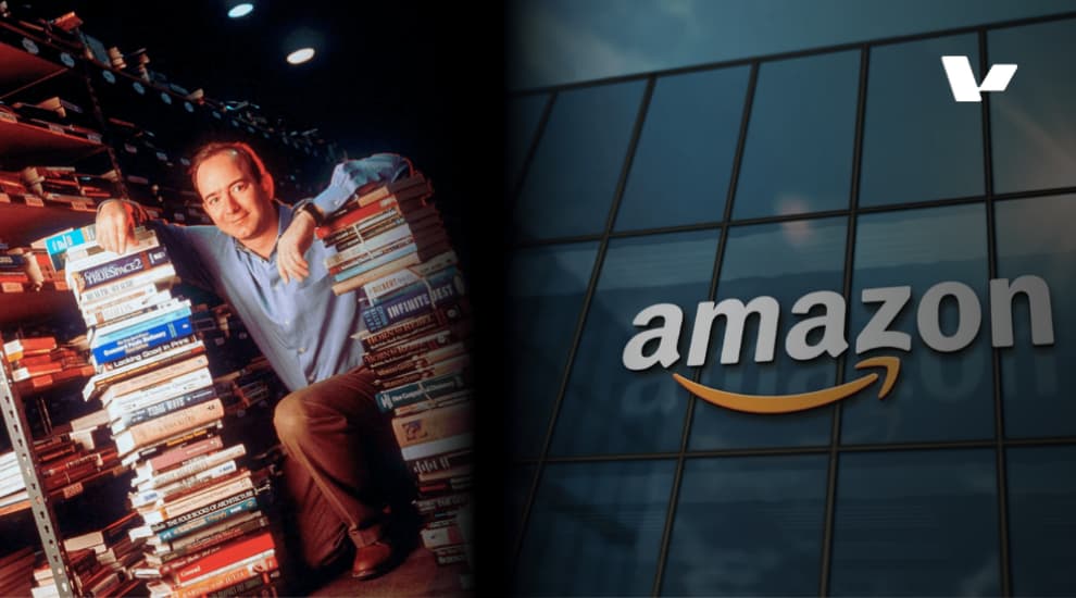 Jeff Bezos kneeling next to piles of books in the early days of Amazon, surrounded by shelves of books.